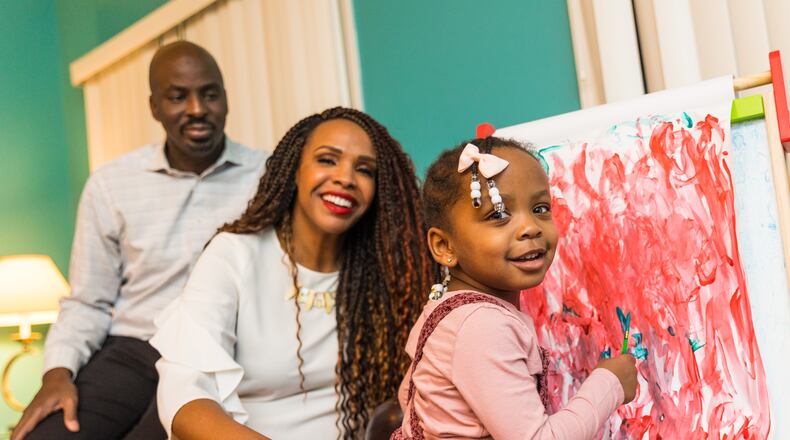 The McCown family is busy with their 2-year-old Priya McCowan, who turns three in early March and just added to her painting at their home.  Emanuel and Penelope McCowan struggled for years with fertility issues. Penelope now has a blog and a small business to help others in her situation.  (Jenni Girtman for The Atlanta Journal-Constitution)