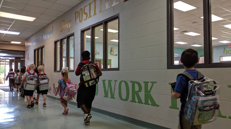 Students file out the front door at Worth County Primary School on May 9, 2019. They are too young for state standardized tests, which start in third grade. But the K-2 school in Sylvester, Ga., used federal grant money to purchase special reading tests to gauge their progress, and on this day, they had their final tests of the year. (The walls are covered with words to emphasize the focus on literacy.) Like all Georgia school districts, Worth County is now getting more federal dollars — an additional $1.1 million — towards coronavirus-related costs.