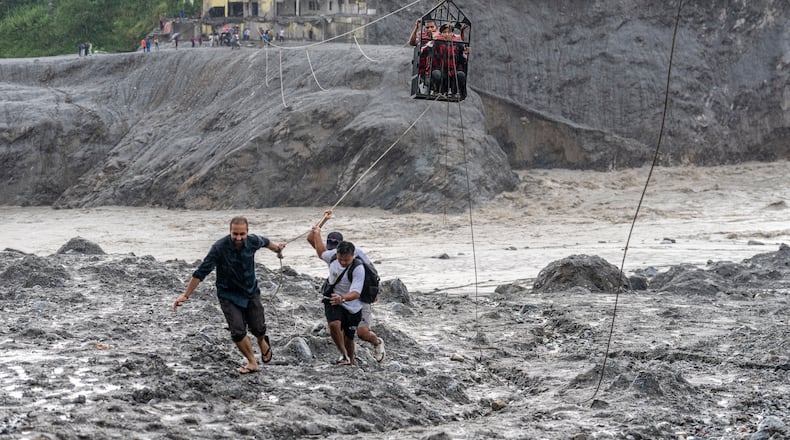 Residents pull a newly installed zipline to help people commute across the Trishuli river in the aftermath of flash floods at Bidur in Nepal's Nuwakot district, Nepal, Wednesday, Sept. 2, 2026. (AP Photo/Rajesh Kumar Singh)