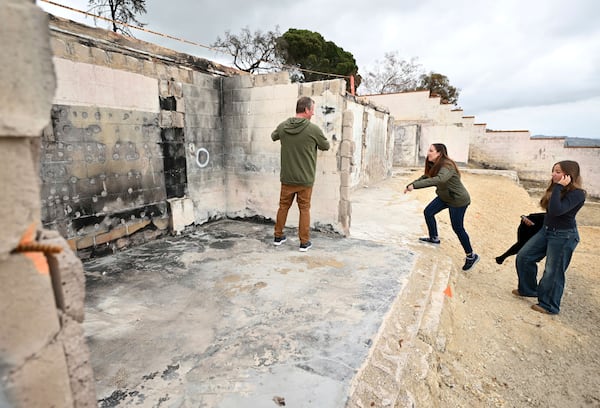 Keith and Rachel McNett along with daughter Teagan, right, visit there house that burned in the Mountain Fire Wednesday, April 16, 2025, in Camarillo, Calif. (AP Photo/Wally Skalij)