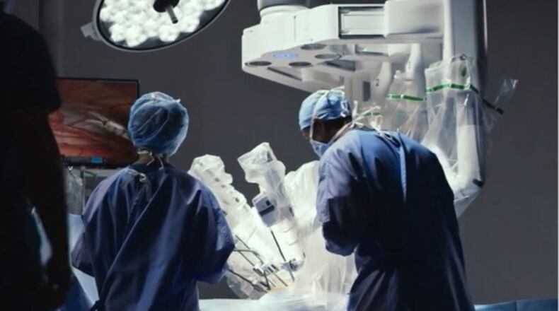 Doctor and surgical assistant working with Intuititive's robotic da Vinci surgical system. (Courtesy Intuitive)