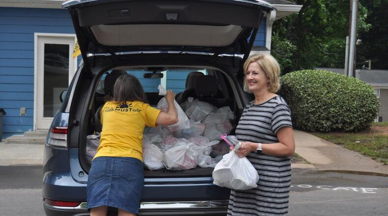 Two volunteers, Eleanor Knox (left) and Nancy Law (right) from First Presbyterian Church in Marietta hand out meals to children for MUST Summer Lunch, a program that works to ease food insecurity for children while they are out of school for the summer.