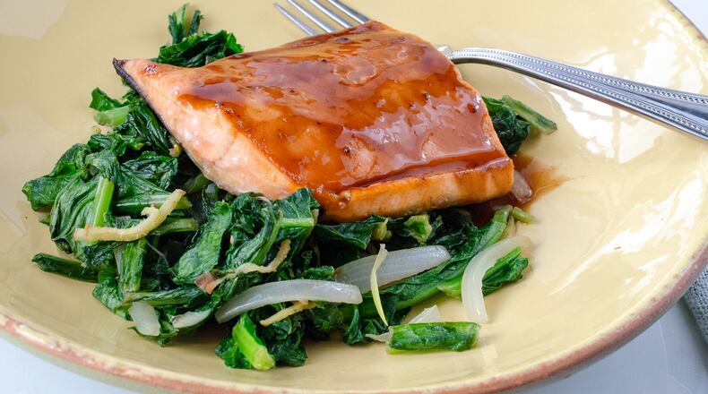 Teriyaki salmon on a bed of sauteed greens with ginger and onion is a dish that comes together quickly.
(Courtesy of Virginia Willis /Food styling Cynthia Graubart)