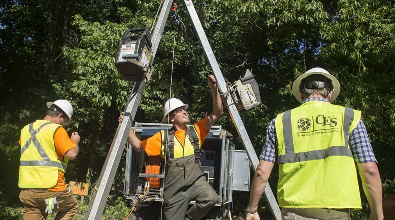 Contractors for Compliance Envirosystems demonstrate their efforts to clean DeKalb County’s sewer system by sending a worker down a manhole behind Marist School in Brookhaven on Wednesday. Chad Rhym/ Chad.Rhym@AJC.com
