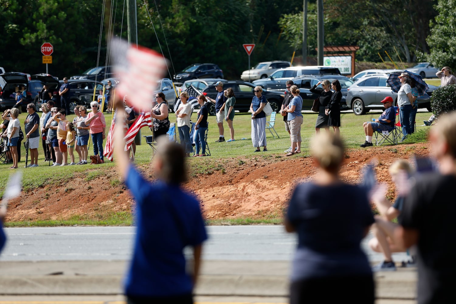 Dozens of people show respect for the procession for Marshall Samual Ervin Jr as they travel on Dallas Highway on Thursday, September 15, 2022, in Dallas, Ga. Marshall Samual Ervin Jr, alongside Cobb County Deputy Koleski, was killed late Thursday while attempting to arrest Christopher James Cook Jr. at home in the Hampton Glen subdivision last week.