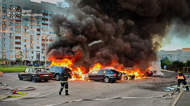 In this photo provided by the Ukrainian Emergency Service, cars burn as firefighters try to put out a fire following a Russian drone attack in Kyiv region, Ukraine, Friday, Aug. 28, 2026. (Ukrainian Emergency Service via AP)