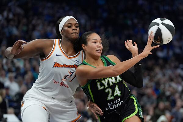 Minnesota Lynx forward Napheesa Collier (24) passes while defended by Phoenix Mercury center Kalani Brown (21) during the second half of a WNBA basketball game Tuesday, June 3, 2025, in Minneapolis. (AP Photo/Abbie Parr)