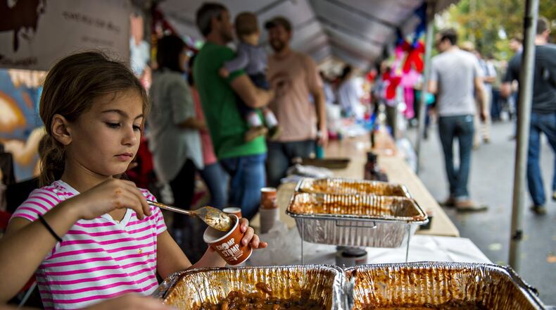 Maya Johnson (left) spoons chili into tasting cups during last year’s Cabbagetown Chomp & Stomp in Atlanta. This year’s event, which also offers bluegrass music, cabbage games and a 5K race, is coming Nov. 5. JONATHAN PHILLIPS / SPECIAL