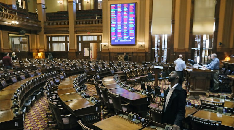 Members of the House Clerk's office staff test voting equipment in the House chamber. BOB ANDRES /BANDRES@AJC.COM