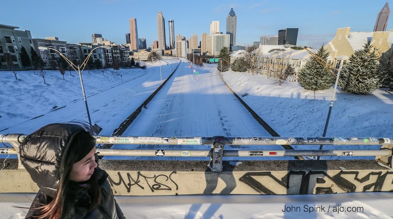 Megan Chen crosses the Jackson Street bridge above a deserted, snow-covered Freedom Parkway below on Wednesday, Jan. 17, 2018, in Atlanta. JOHN SPINK/JSPINK@AJC.COM
