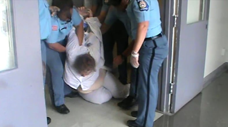 An undated photo from a prison video shows officers at Lee Arrendale State Prison trying to pull inmate Mollianne Fischer to her feet and get her to walk to an isolation cell. In 2014, Fischer was left in a vegetative state after she failed to receive adequate medical care at Pulaski State Prison. Her family was awarded $1.5 million. (Contributed)