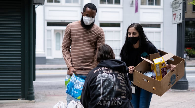200923-Atlanta-Brandon Russ, left, and Donia Hanaei, harm reduction specialists with the Atlanta/Fulton Pre-Arrest Diversion Initiative (PAD), talks with a person at Woodruff Park in downtown Atlanta on Wednesday, September 23, 2020. PAD helps divert people who face an immediate arrest to social services that can address the persons needs and keep them out of the legal system. Ben Gray for the Atlanta Journal-Constitution