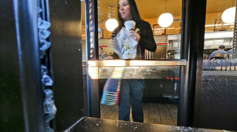 Rachel Troiano leaves a Kennesaw Waffle house Friday morning following an overnight shooting. A suspect was in custody Friday morning. JOHN SPINK/JSPINK@AJC.COM