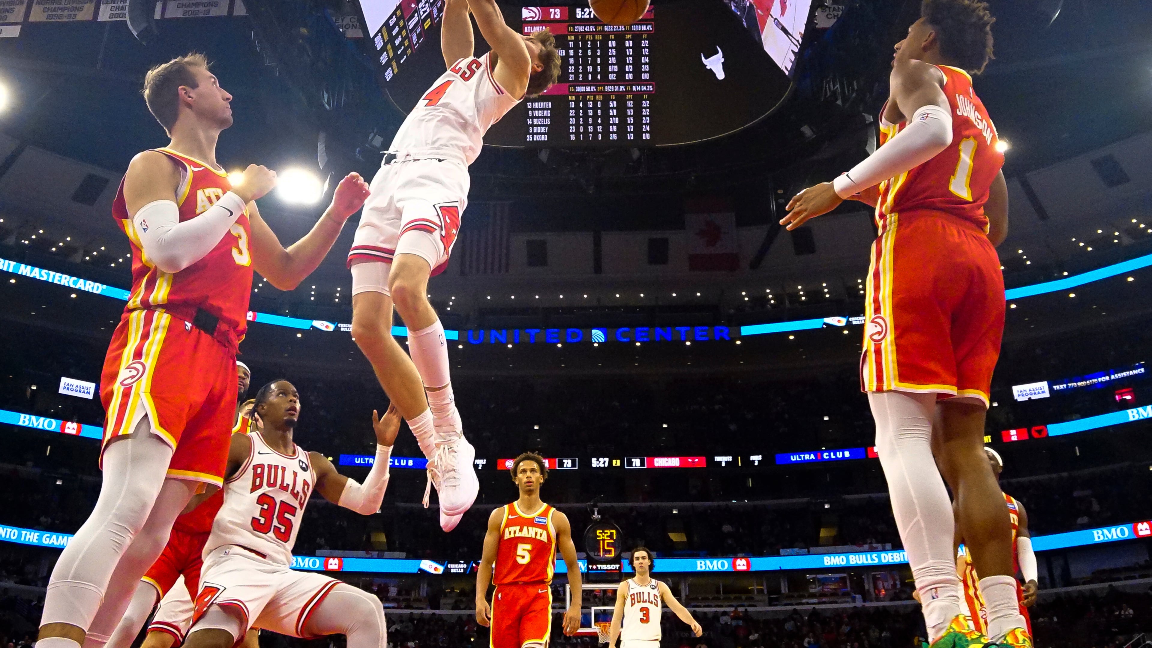 Chicago Bulls forward Matas Buzelis, center, dunks the ball on Atlanta Hawks guard Luke Kennard, left, and forward Jalen Johnson during the second half of an NBA basketball game Monday, Oct. 27, 2025, in Chicago. (AP Photo/David Banks)