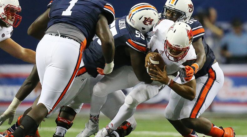 090515 ATLANTA: Louisville quarterback Reggie Bonnafon is sacked by Auburn defenders Carl Lawson (center) and Dontavius Russell (right) during the second quarter in the Chick-fil-A Kickoff Game on Saturday, Sept. 5, 2015, in Atlanta. Curtis Compton / ccompton@ajc.com
