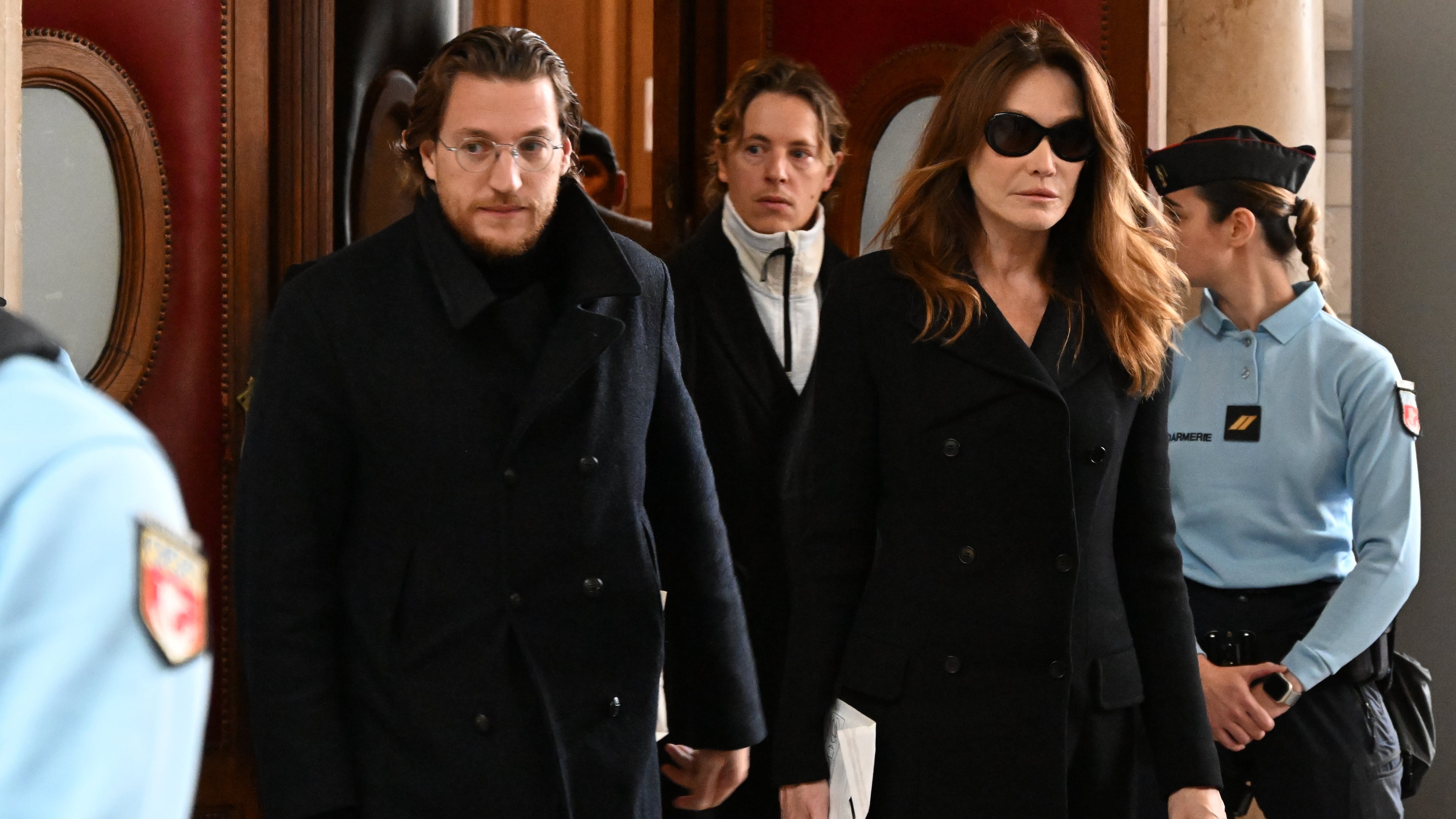 Former French President Nicolas Sarkozy's wife Carla Bruni-Sarkozy and son Jean Sarkozy leave a Paris court before it decides whether to release Sarkozy from prison, less than three weeks after he began serving a five-year sentence for criminal conspiracy in a scheme to finance his 2007 election campaign with funds from Libya, Monday, Nov. 10, 2025 in Paris. (AP Photo/Emma Da Silva)