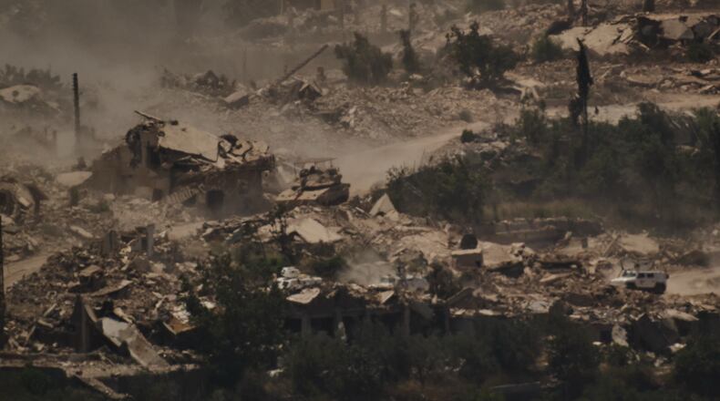 FILE - An Israeli tank moves past a convoy of the United Nations peacekeeping forces in Lebanon (UNIFIL) in southern Lebanon, as seen from northern Israel on June 26, 2026. (AP Photo/Leo Correa, File)