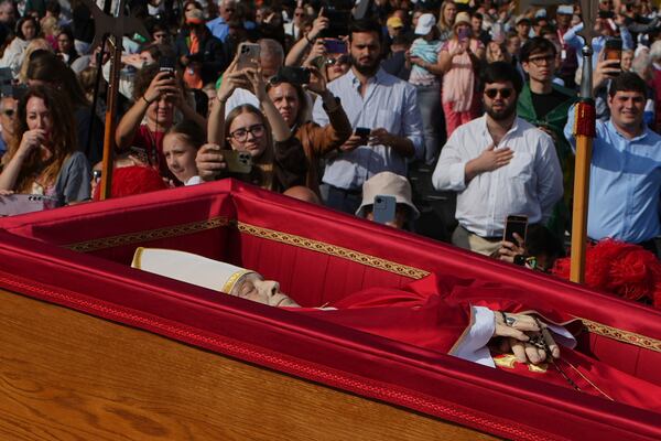 The body of Pope Francis is carried into St. Peter's Basilica at the Vatican, Wednesday, April 23, 2025, where he will lie in state for three days. (AP Photo/Emilio Morenatti)