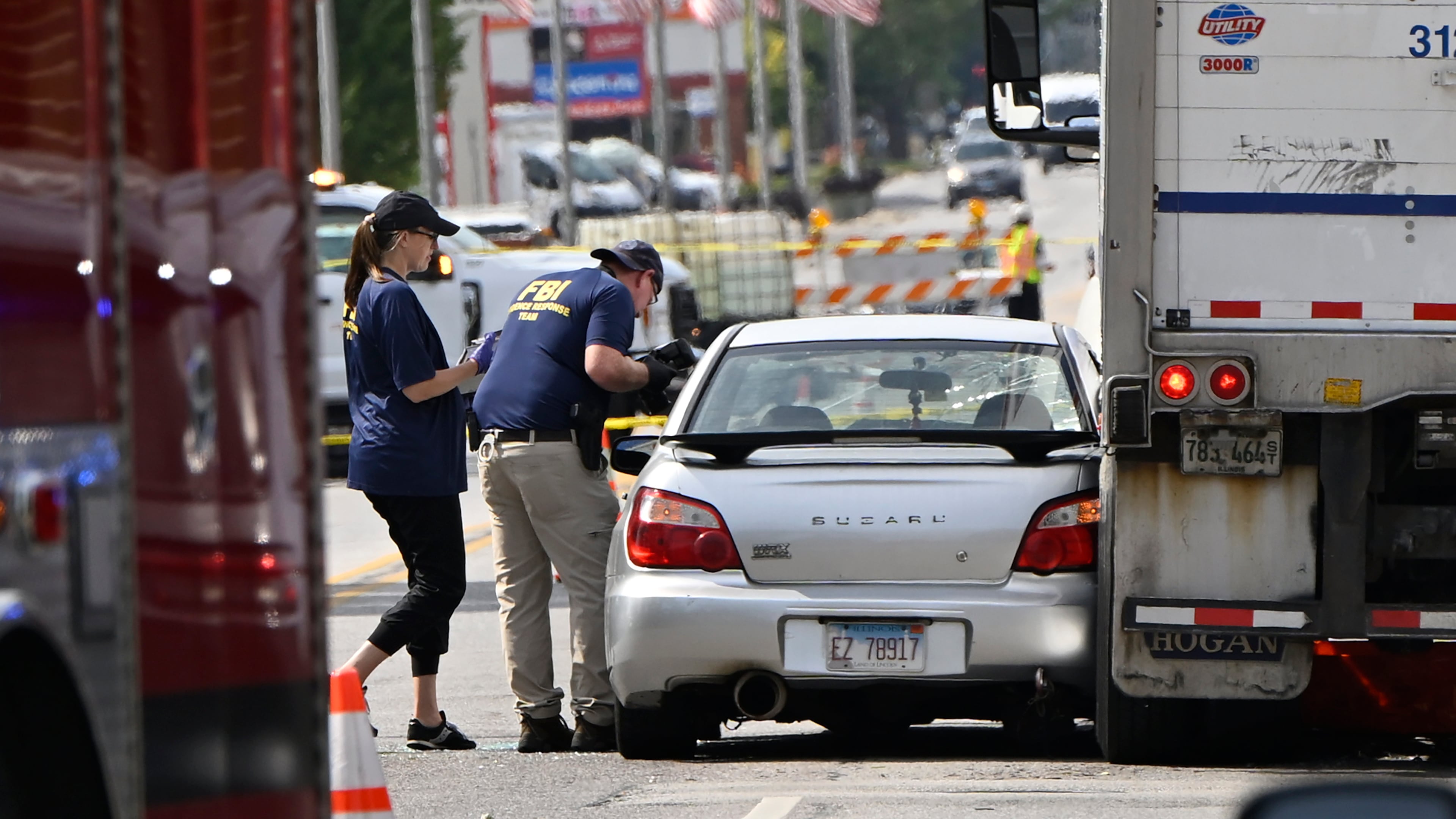 Investigators from the FBI survey the scene where an Immigration and Customs Enforcement officer shot and killed a suspect after the suspect drove his car at the arresting officers, Friday, Sept. 12, 2025, in Franklin Park, Ill. (AP Photo/Paul Beaty)