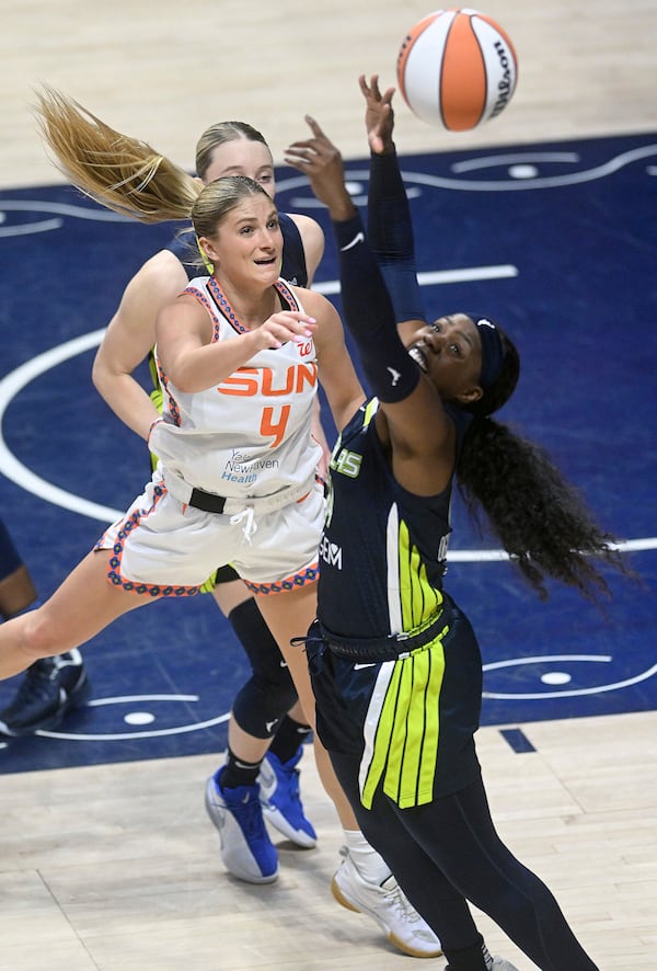 Connecticut Sun's Jacy Sheldon (4) throws a pass past Dallas Wing's Arike Ogunbowale (24) during a WNBA basketball game Tuesday, May 27, 2025, in Uncasville, Conn. (Sarah Gordon/The Day via AP)
