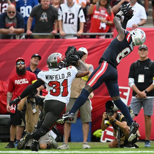 New England Patriots wide receiver Stefon Diggs (8) catches a pass for a touchdown against Tampa Bay Buccaneers safety Antoine Winfield Jr. (31) during the first half of an NFL football game Sunday, Nov. 9, 2025, in Tampa, Fla. (AP Photo/Jason Behnken)