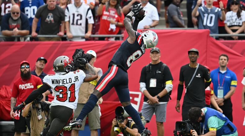 New England Patriots wide receiver Stefon Diggs (8) catches a pass for a touchdown against Tampa Bay Buccaneers safety Antoine Winfield Jr. (31) during the first half of an NFL football game Sunday, Nov. 9, 2025, in Tampa, Fla. (AP Photo/Jason Behnken)