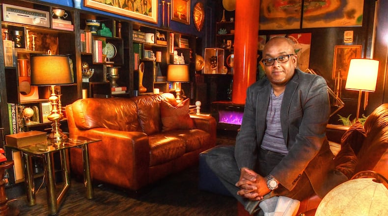 Owner Doug Hines sits in one of the coves in the midcentury decorated the Consulate restaurant in Midtown Atlanta. Hines, a graphic designer by trade who expanded into interior design, purchased items and decorated much of the space himself. Hines is quoted offering critique of "vibe"-driven restaurants in Jordan's story at Eater Atlanta, titled "Good Vibes, Hospitality Not Included."