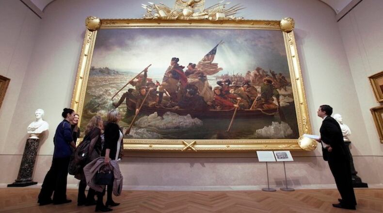 In this Jan. 12, 2012 photo, visitors to the American Wing of the Metropolitan Museum of Art, in New York, view “Washington Crossing the Delaware,” by Emanuel Gottlieb Leutze. When the Metropolitan Museum of Art opens its dramatic new American Wing Galleries for Paintings, Sculpture and Decorative Arts this month, treasures from the 18th to the early 20th century are bound to captivate the public as never before. (AP Photo/Richard Drew)