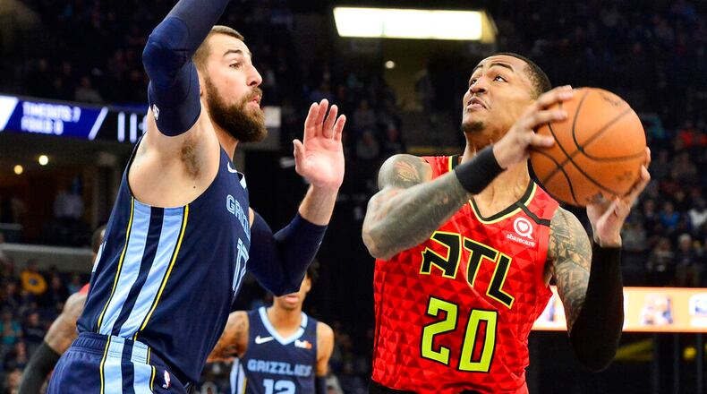 Atlanta Hawks forward John Collins (20) looks to shoot against Memphis Grizzlies center Jonas Valanciunas (17) in the first half of an NBA basketball game Saturday, March 7, 2020, in Memphis, Tenn. (AP Photo/Brandon Dill)
