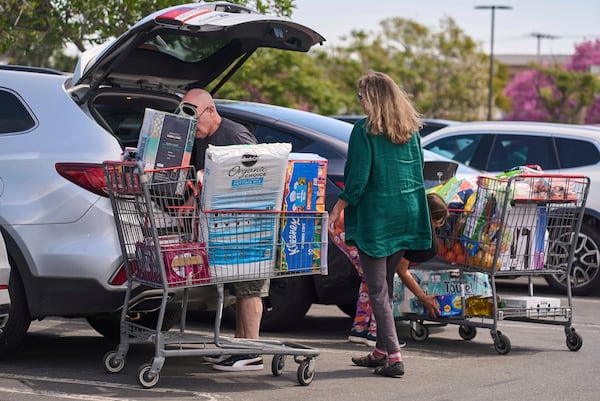 FILE - People pack their supplies into their vehicles at Costco Wholesale store in Burbank, Calif., on Thursday, April 10, 2025. (AP Photo/Damian Dovarganes, File)