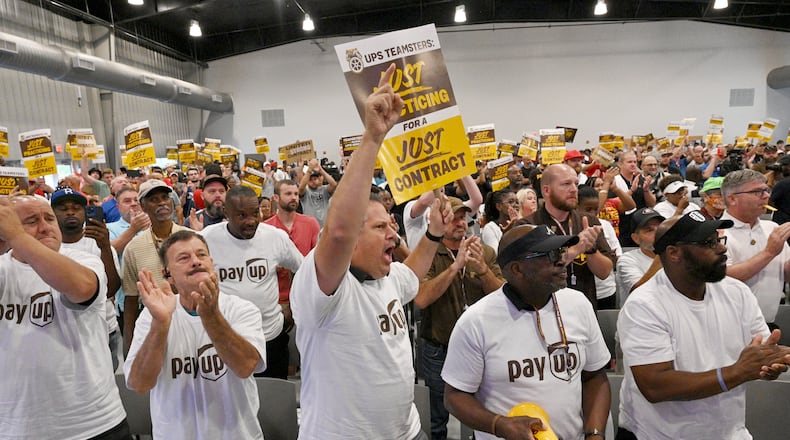 Phil Prince (center) holds a sign to show his support as Teamsters General President Sean O’Brien (not pictured) speaks during a rally just days before high-stakes contract talks with UPS are set to resume, at Teamsters Local 728, Saturday, July 22, 2023, in Atlanta. The head of the International Brotherhood of Teamsters revved up the union’s membership in Atlanta on Saturday at a rally just days before high-stakes contract talks with UPS are set to resume. (Hyosub Shin / Hyosub.Shin@ajc.com)