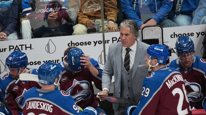 Colorado Avalanche head coach Jared Bednar, back right, confers with center Nathan MacKinnon, front right, and left wing Gabriel Landeskog in the third period of Game 2 of an NHL hockey Stanley Cup second-round playoff series against the Minnesota Wild Tuesday, May 5, 2026, in Denver. (AP Photo/David Zalubowski)