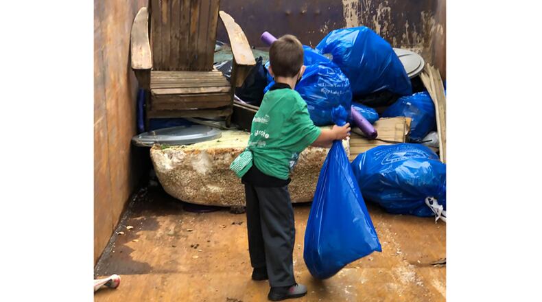 A young volunteer helps collect trash during the 32nd annual Shore Sweep of the Lake Lanier Association.