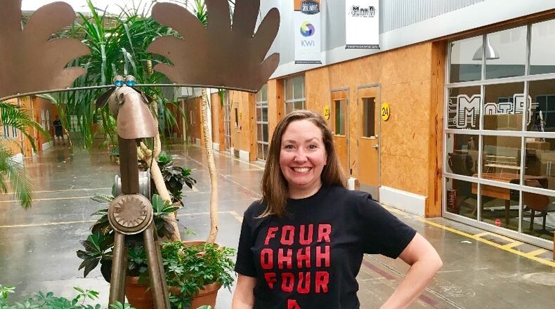 Shannon Kroll shows off The Stove Works on Krog Street in Atlanta. Twenty-four hours after this photo was taken 45 vendors comprising Root City set up shop in this hallway. Kroll bought Root City, a pop up market, in December. The moose to her right did not get a booth. Bill Banks for the AJC