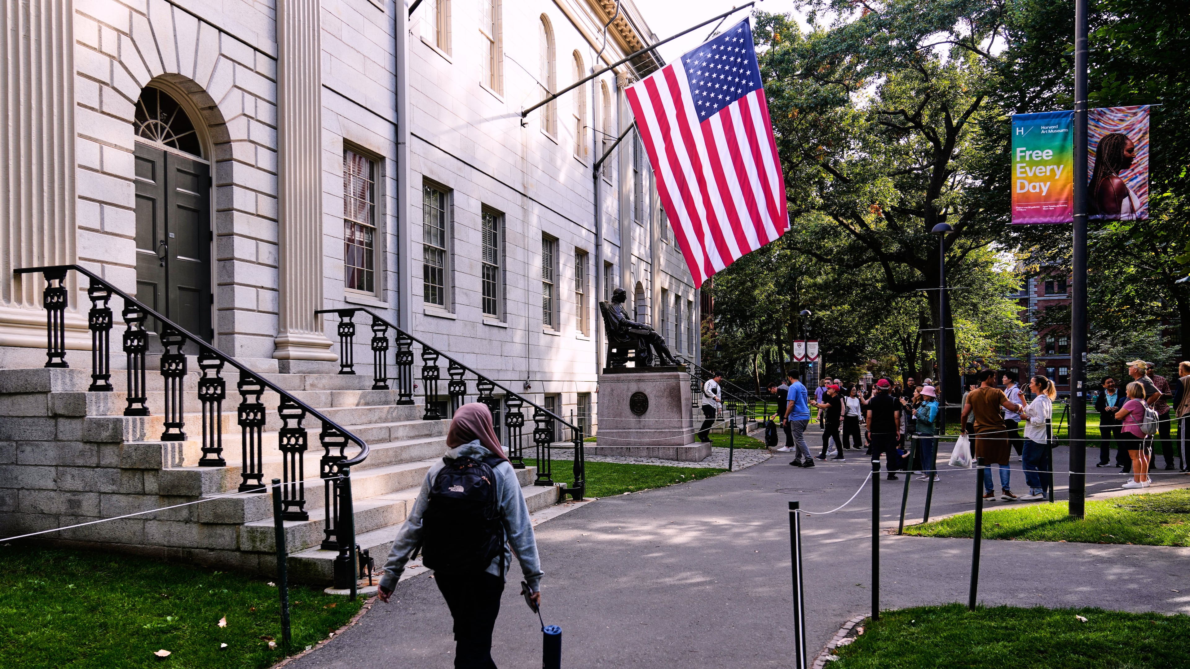 A woman walks through Harvard Yard at Harvard University, Tuesday, Sept. 30, 2025, in Cambridge, Mass. (AP Photo/Charles Krupa)