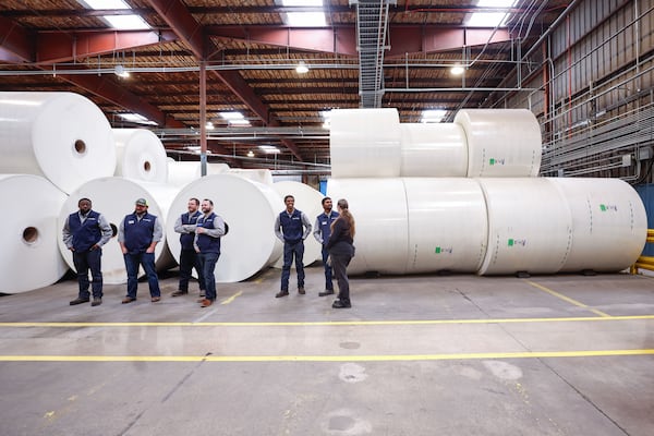Saint-Gobain employees stand in front of glass mat rolls at the factory in Peachtree City on Friday, Feb. 13, 2026. The company recently underwent an expansion of the facility. Natrice Miller/AJC)