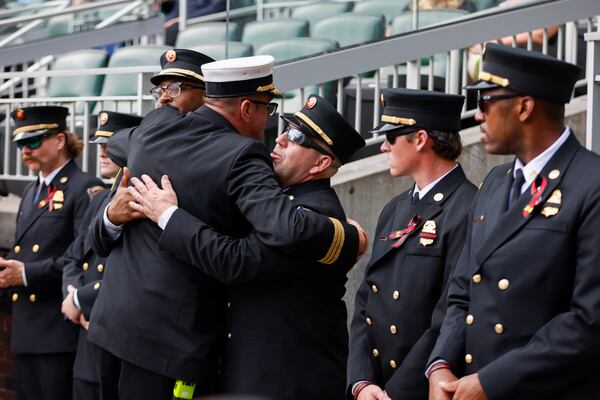 Firefighters from metro Atlanta greet each other during the memorial service for fallen DeKalb firefighter Preston Fant at Truist Park. (Arvin Temkar/AJC)