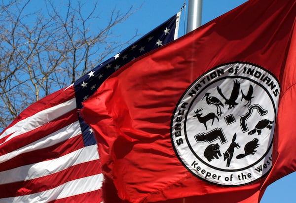 FILE - A Seneca Nation of Indians flag waves alongside an American flag during a news conference outside the Tribal Council building in Irving, N.Y., on April 19, 2007. (AP Photo/Don Heupel, File)