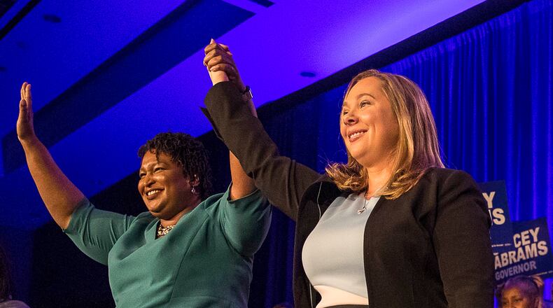 Gubernatorial candidate Stacey Abrams links hands with Sarah Riggs Amico, the nominee for lieutenant governor, during a 2018 state Democrat convention. AJC file.