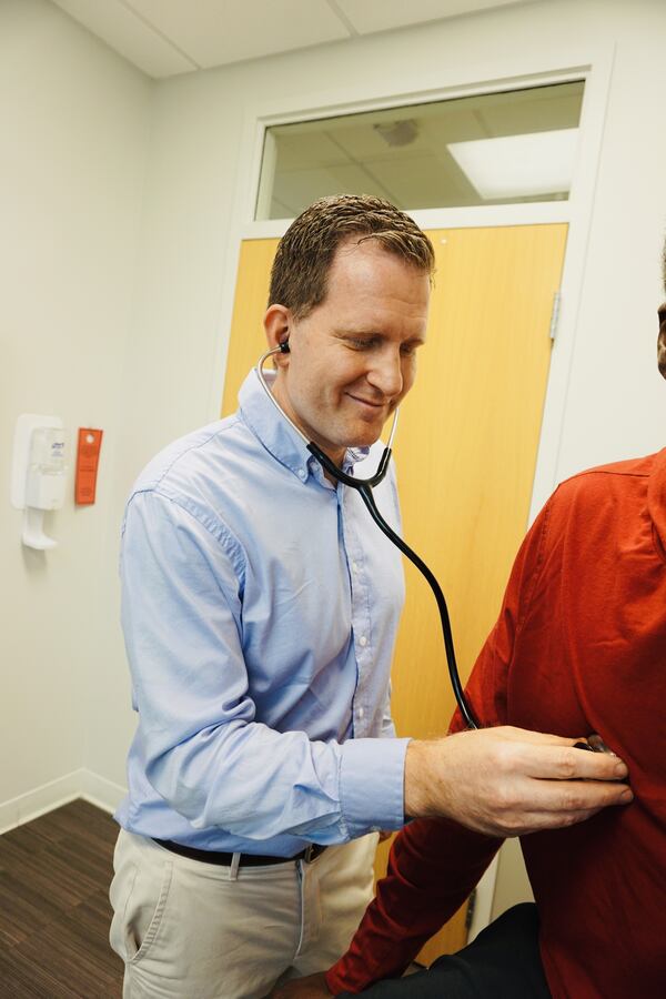 Wellstar emergency room doctor Andrew Thornton listens to a patient's heart. He said surveys and studies show women are more likely to see a doctor than men. (Courtesy of Wellstar Health System) 