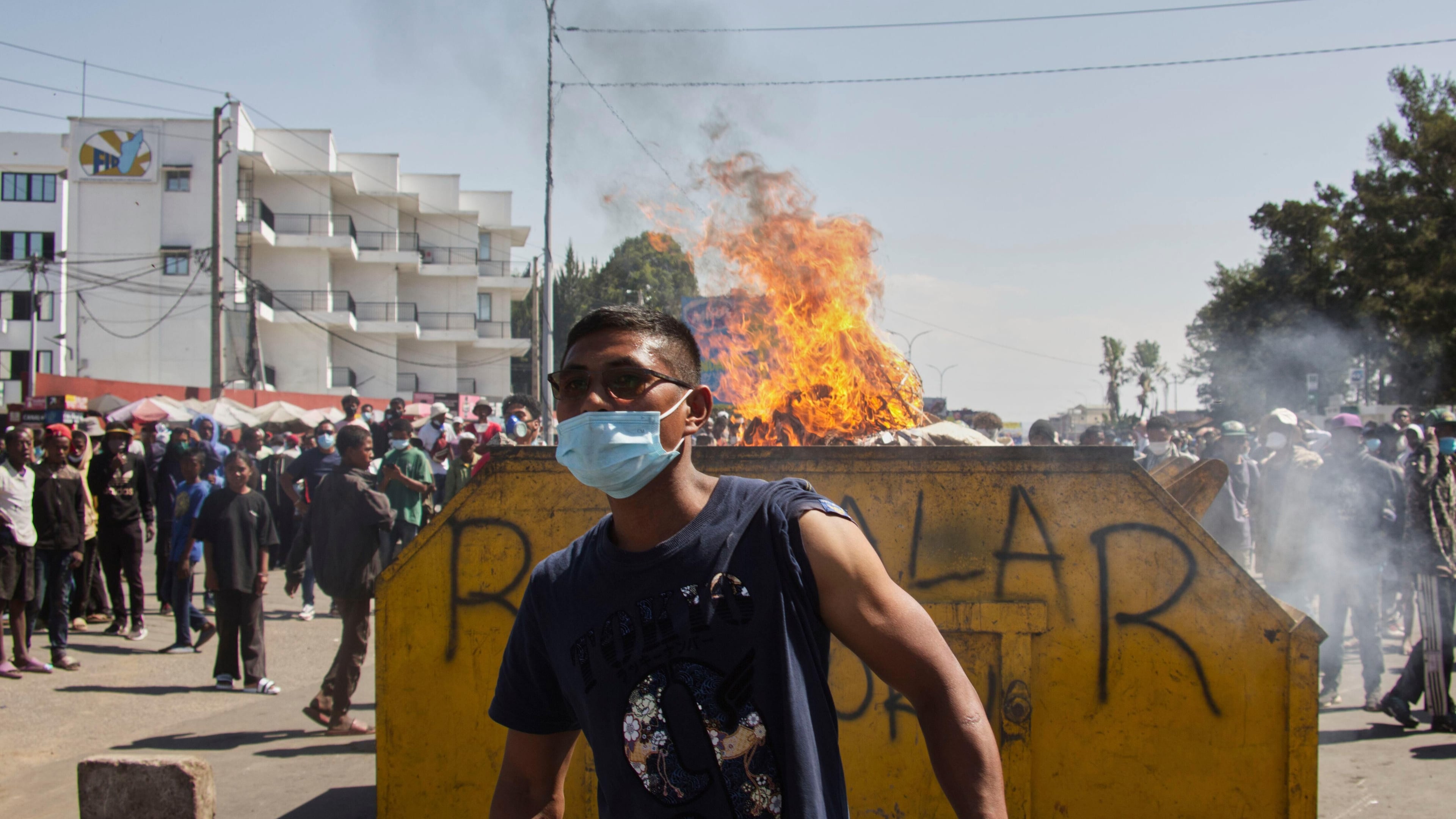 An protester watches police near burning barricades during a protest calling for the president to step down in Antananarivo, Madagascar, Thursday, Oct. 9, 2025. (AP Photo/Alexander Joe)