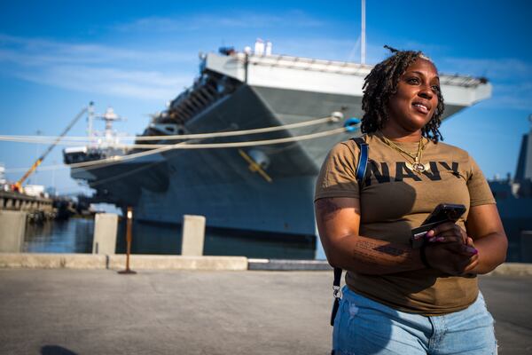 Latoya Savoy stands in front of the USS Gerald R. Ford aircraft carrier leaves Naval Station Norfolk with her daughter (unnamed), a U.S. Navy sailor who works in aviation ordinance on Tuesday, June 24, 2025, in Norfolk, Va. (AP Photo/John Clark)