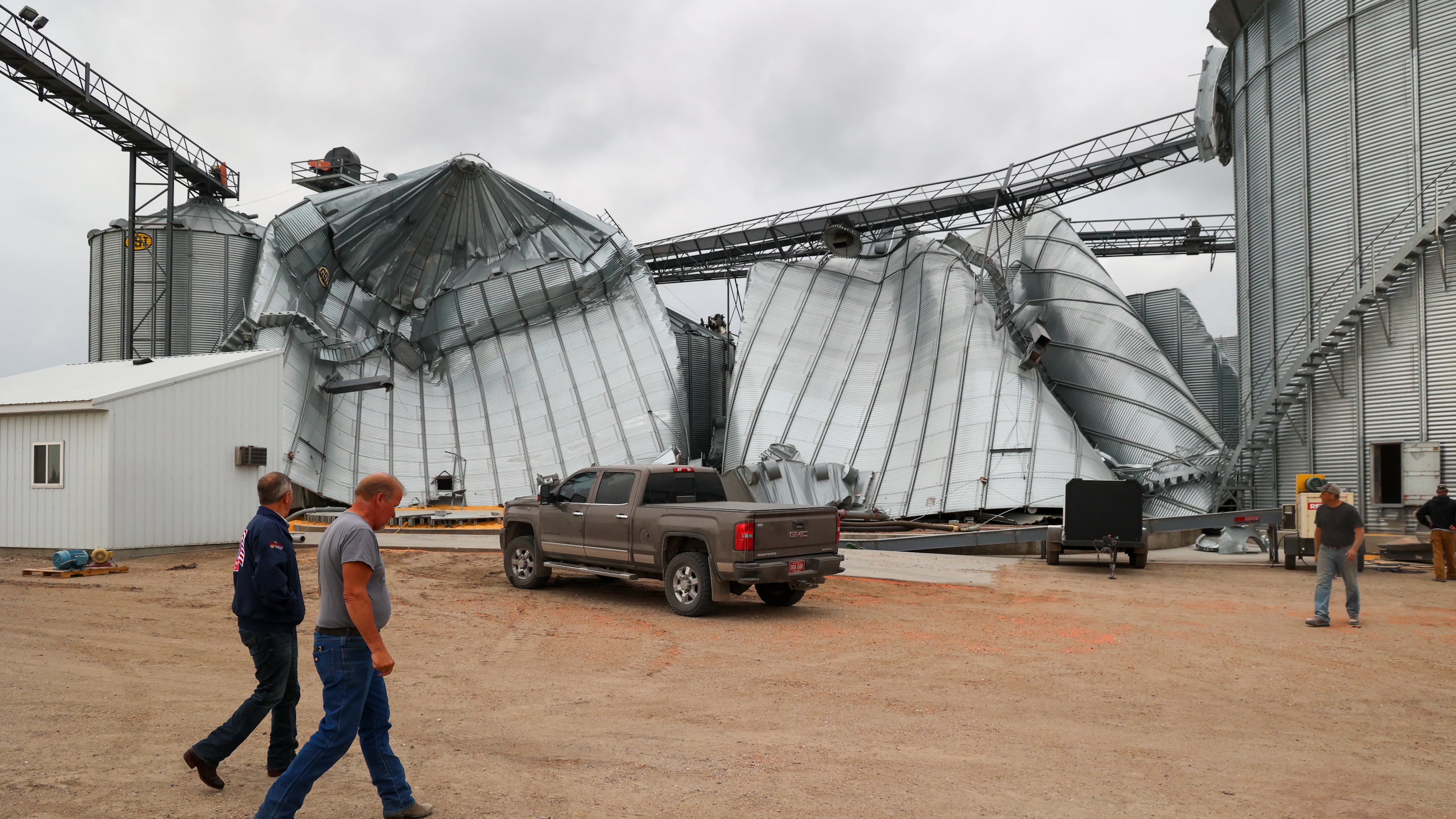 North Dakota Governor Kelly Armstrong walks by silos damaged by an EF5 tornado in Enderlin, N.D., on June 25, 2025. (North Dakota Governor's Office via AP)