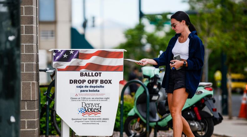 A woman drops off her mail-in ballot outside the Denver Elections Division polling center as she votes in June's Colorado primary. (Michael Ciaglo/Getty Images/TNS)