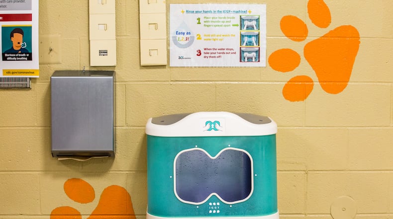 "Iggy", 30e Scientific's first aqueous ozone hand washing station is installed in the Bryant Elementary School cafeteria in Mableton. The sanitation station uses ozone, a natural disinfectant, to clean elementary school hands in seven seconds before students pick up their school lunches. The Cobb County School District and the makers of the three sanitation systems installed at the school share information before moving into demonstrates of the technologies Wednesday, Oct 21, 2020. (Jenni Girtman for The Atlanta Journal-Constitution)