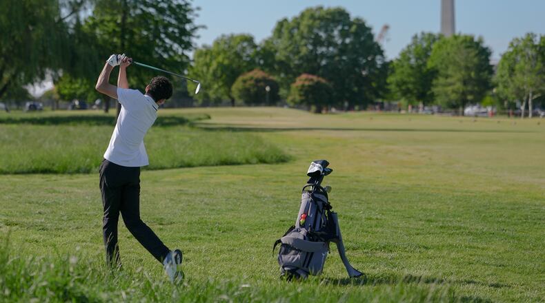 The Washington Monument stands in the background as Roman Sandoli swings at the East Potomac Golf Course, Sunday, May 3, 2026, in Washington. (AP Photo/Julia Demaree Nikhinson)