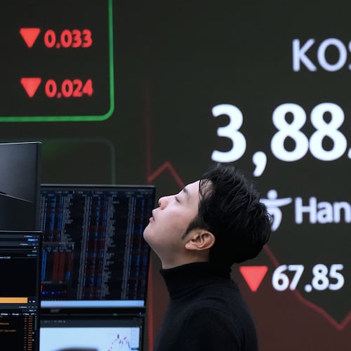 A currency trader reacts near a screen showing the Korea Composite Stock Price Index (KOSPI) at the foreign exchange dealing room of the Hana Bank headquarters in Seoul, South Korea, Wednesday, Nov. 19, 2025. (AP Photo/Ahn Young-joon)