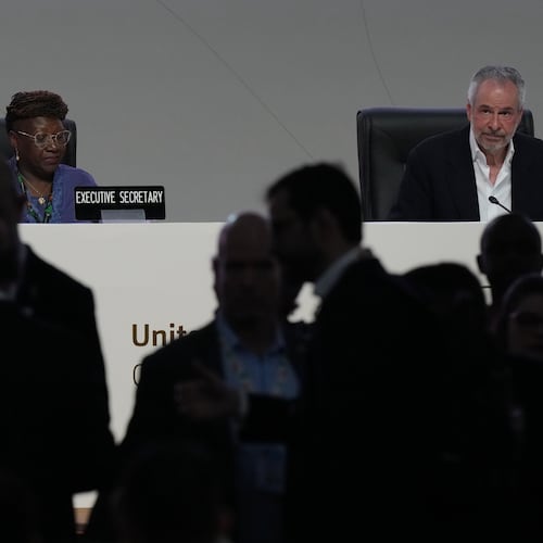 People come and go from a plenary session as André Corrêa do Lago, COP30 president, sits at back right, during the COP30 U.N. Climate Summit, Monday, Nov. 17, 2025, in Belem, Brazil. (AP Photo/Fernando Llano)