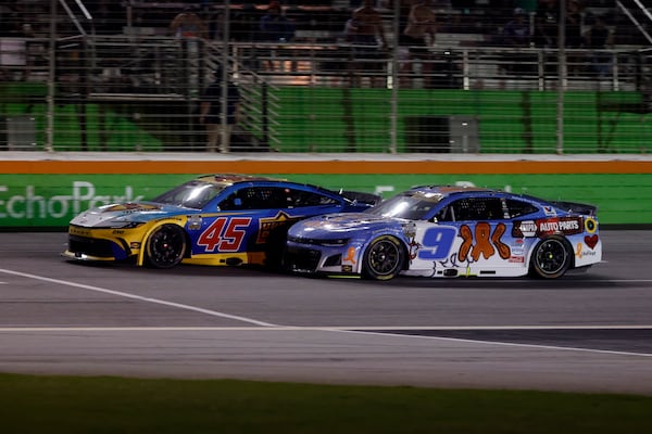 Tyler Reddick (45) races Chase Elliott (9) to the line to win Stage Two during a NASCAR Cup Series auto race, Saturday, June 28, 2025, in Hampton, Ga. (AP Photo/Butch Dill)