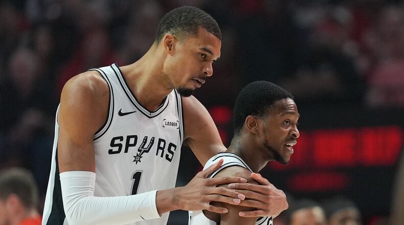 San Antonio Spurs forward/center Victor Wembanyama (1) reacts with guard De'aaron Fox after aplay during the first half in Game 4 of a first-round NBA basketball playoffs series against the Portland Trail Blazers, in Portland, Ore., Sunday, April 26, 2026. (AP Photo/Jenny Kane)